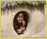 Batarammimba child peers out of a 'Takienta' tower house in the Koutammakou region (UNESCO world heritage site, Togo)